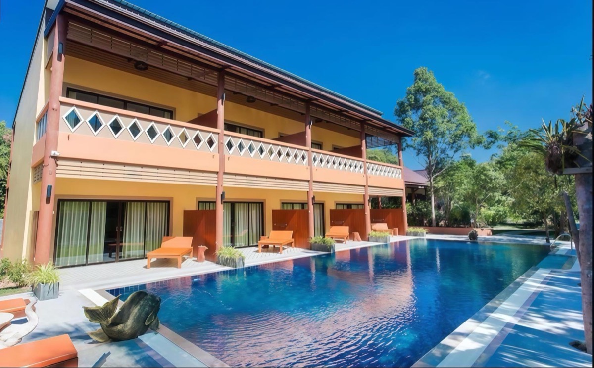 The long pool with sun loungers, in front of the guest rooms