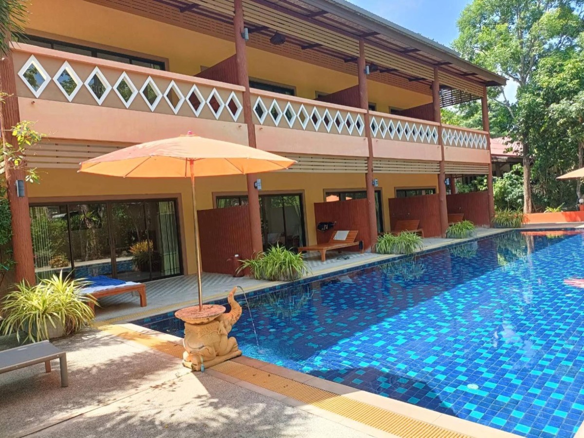 A parasol and sun beds at the edge of the pool