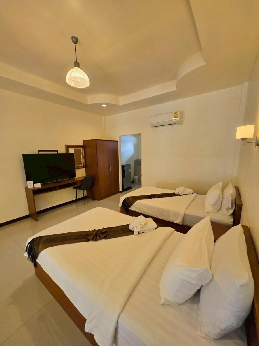 Two beds, a wardrobe and a flat-screen TV in the room